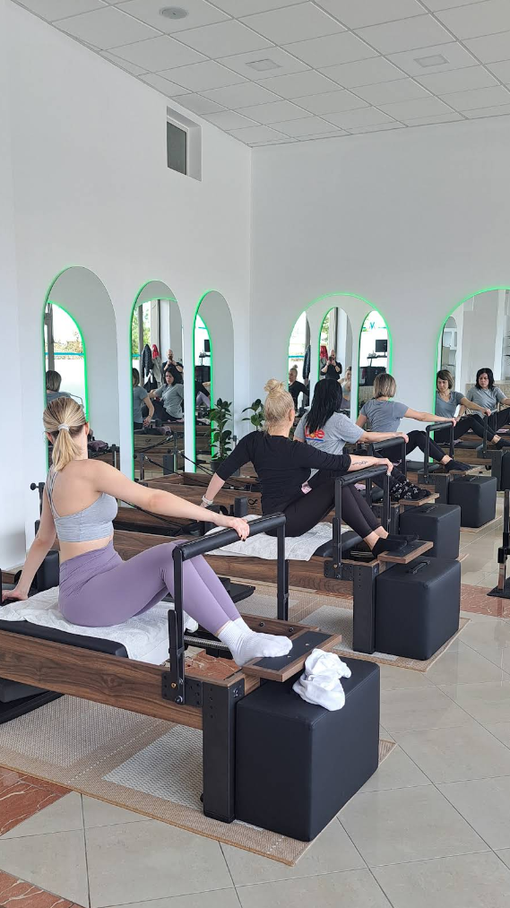 Ασκούμενοι σε συνεδρία Pilates Reformer στο φωτεινό studio της Μάνδρας